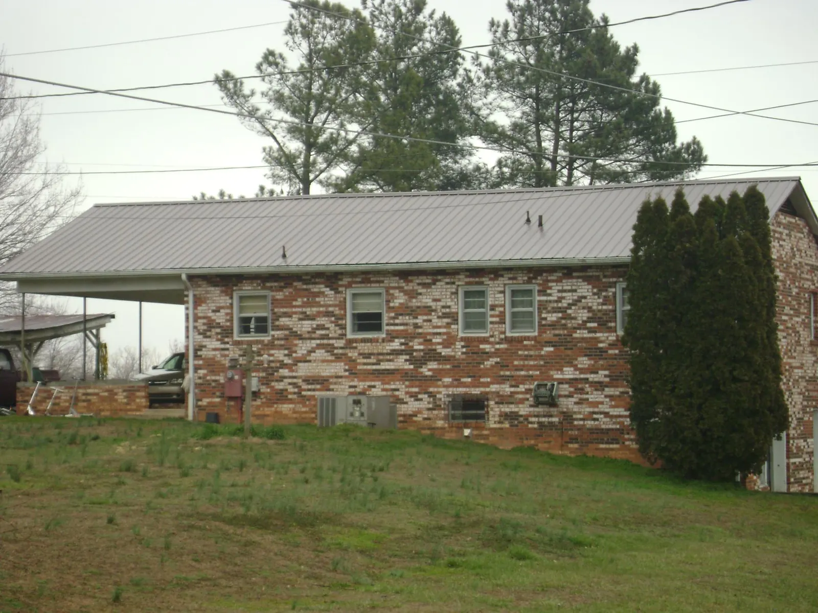 Gray metal roof on a brick split level home with a carport in Atlanta